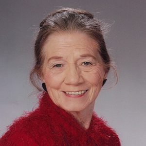 White woman smiling in red fur coat