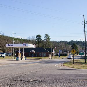 Gas station canopy and building on street with brick buildings in the background