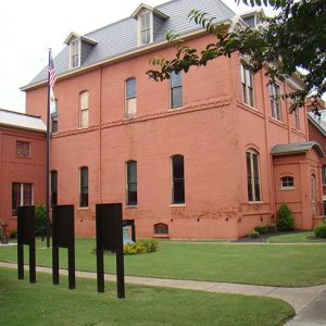 Three-story building with two-story wing with walking paths and signs