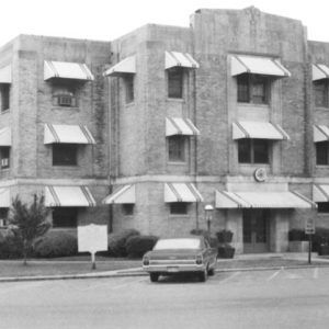 Three-story brick bulding with parking lot