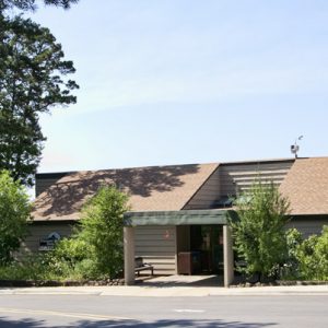 Single-story building with bulletin board sign and parking lot