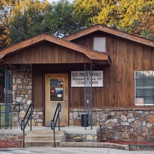 Single-story building with covered porch wood paneling and rock facade