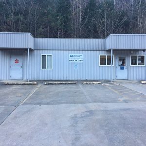 Single-story post office building with parking lot