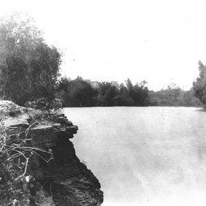 Rock outcropping over river with trees on both sides