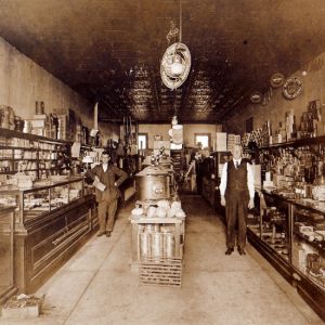 White men in suit and tie in store with items in glass cases