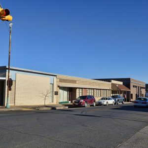 Brick buildings on street with parked cars and traffic signs