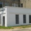 Single-story jail building outside multistory building on street