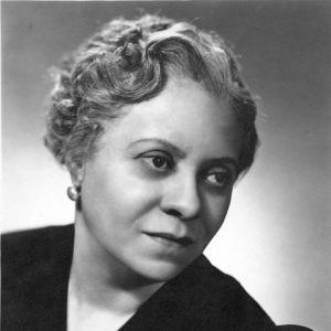 African-American woman with curly hair and earrings in a dress