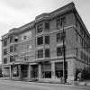 Four-story brick building and street with power lines