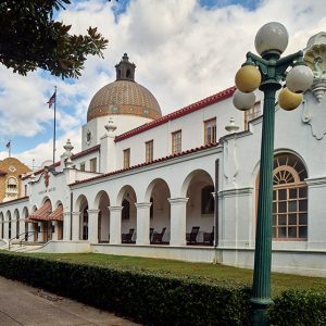 Multistory white building with cupola and red tile roof