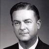 White man grinning in suit and tie