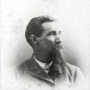 White man with long beard in suit and tie