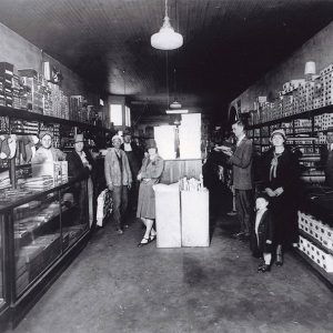 White men and women in store with glass display cases and boxes lining the wall