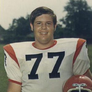 Young white man in orange and white uniform with helmet