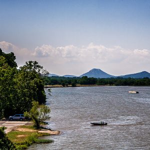 Boats in lake with mountains and trees in the background