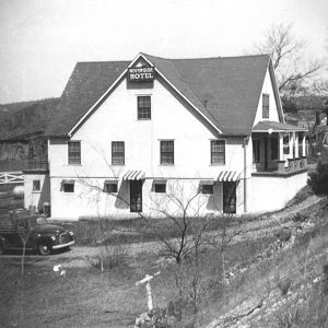 Multistory "Riverside Hotel" building with covered porch