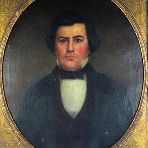 White man with dark hair in black suit and bow tie