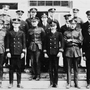 Group of white men in military uniforms with caps