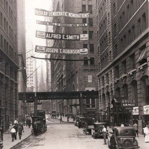 Four Democratic Party political banners stretched between tall buildings over a city street