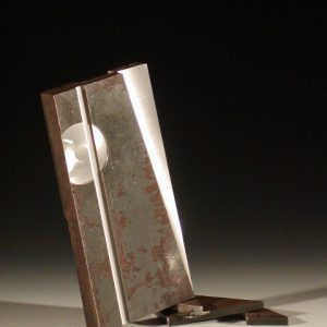 Flat stock steel sculpture with cut out sections then stacked propping original piece at angle