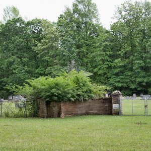 Cemetery inside fence with brick wall and gate with brick columns