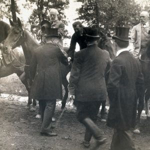 White men on horseback with white men in suits on foot