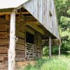 Close-up of wooden barn with metal roof and gate