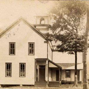 Multistory building with covered porch and bell tower