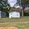 Garage building next to small single-story building with trees in the background