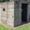 One room concrete jail building with tiny widows and open door