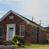 Single-story brick building with plaque above the door