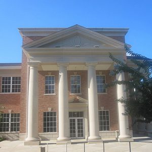 multistory building with windows and four columns in front