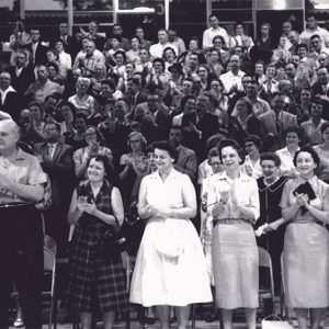 Large group of people standing on raised bleachers