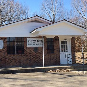 Single-story brick building with covered porch on parking lot