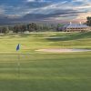 Blue flag on fairway with sand traps hills and multistory building in the background