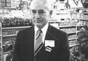 Old white man in suit and tie standing in store