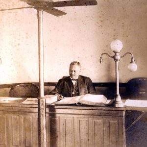 African-American man in suit and bow tie sitting in a courtroom