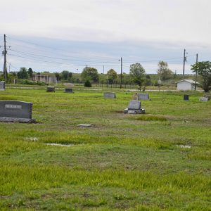 Gravestones in cemetery with highway bridge in the background