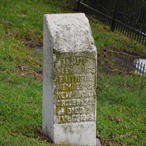 Weathered stone memorial with raised engraving on grass