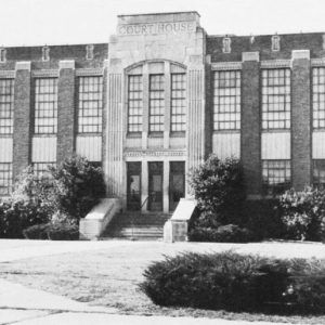 Brick building with paneled windows and arched entrance