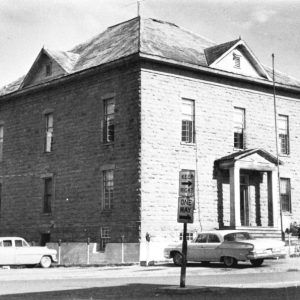 Two-story brick building with street signs and parking lot