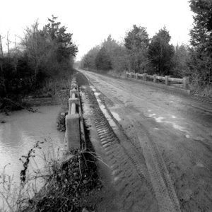 Rural road over concrete bridge over creek