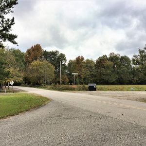 Rural street intersection with paved road bisecting gravel roads