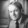 White man smiling in suit and tie