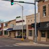 Street with brick and stone storefronts and traffic lights