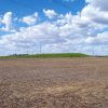 Mound of earth with flat land around it under blue skies