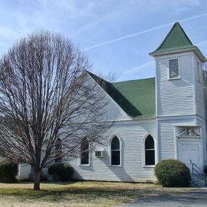 Multistory white building with gothic arch windows and tower entrance