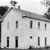 Multistory building with belfry on roof and wood siding