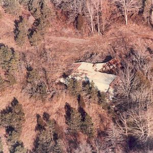 Damaged silo door in forested area