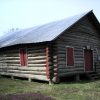 Single-story cabin building with covered windows